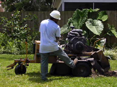 Man Removing Tree Stump With Grinder
